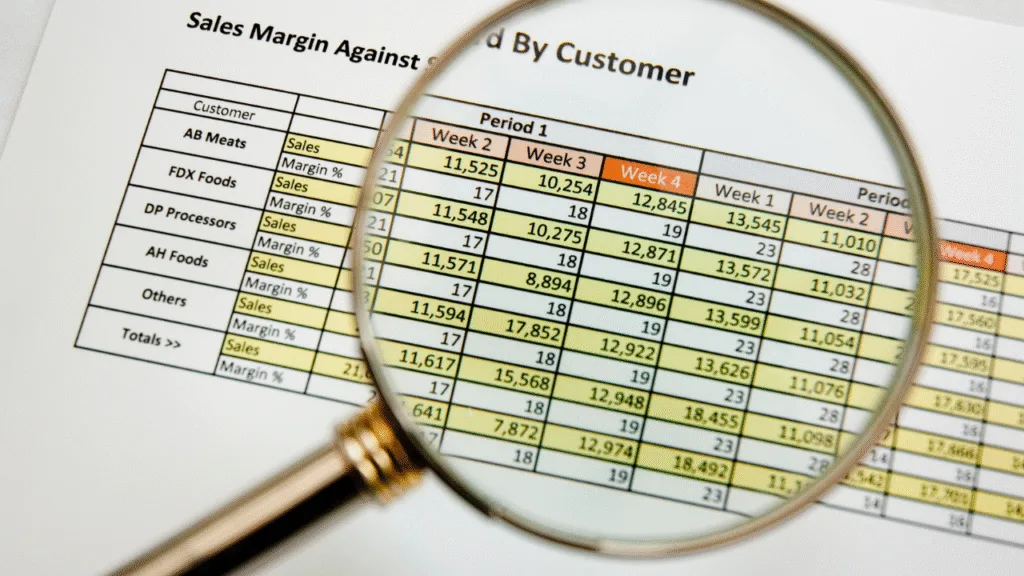 A construction project manager uses a tablet to review real-time job cost budgeting data and variance reports against project plans at a busy construction site.