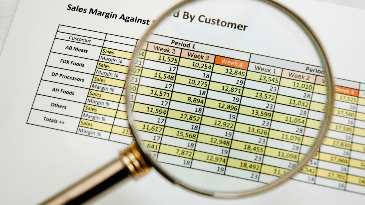 A construction project manager uses a tablet to review real-time job cost budgeting data and variance reports against project plans at a busy construction site.